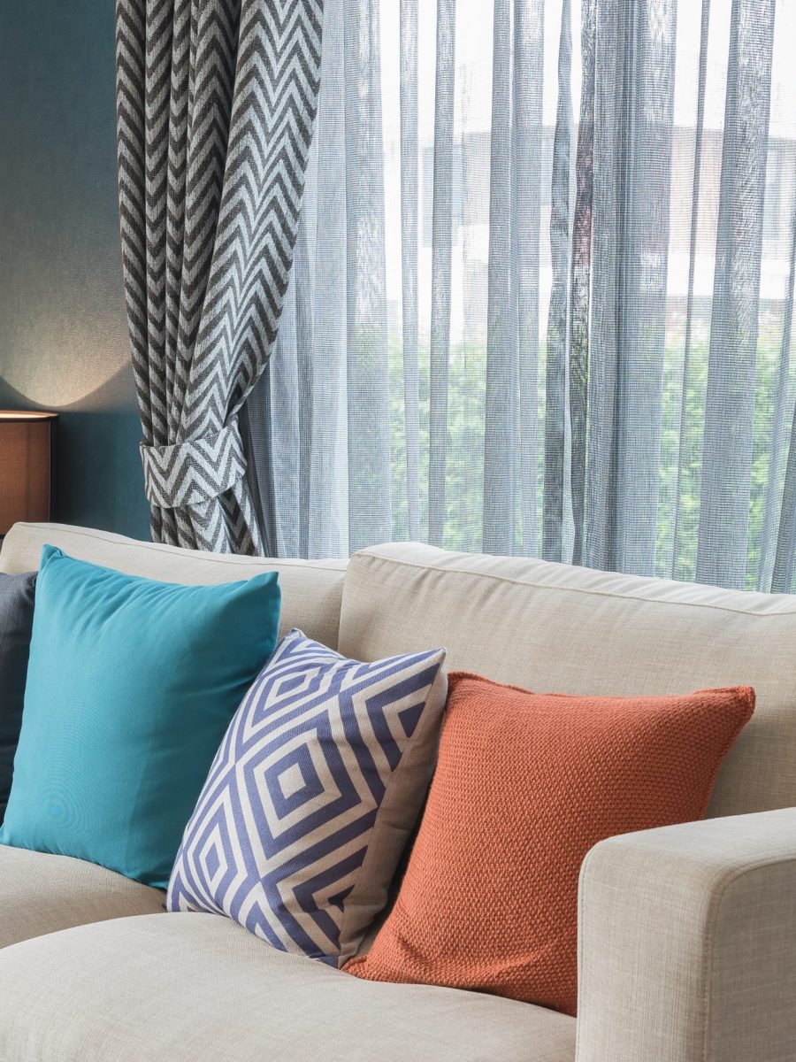 colorful pillows on modern sofa in modern living room, interior design concept