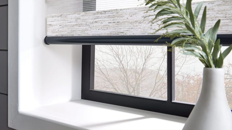 Decorative grey vases on a table against a window fitted with patterned light grey vision blinds in Rochester